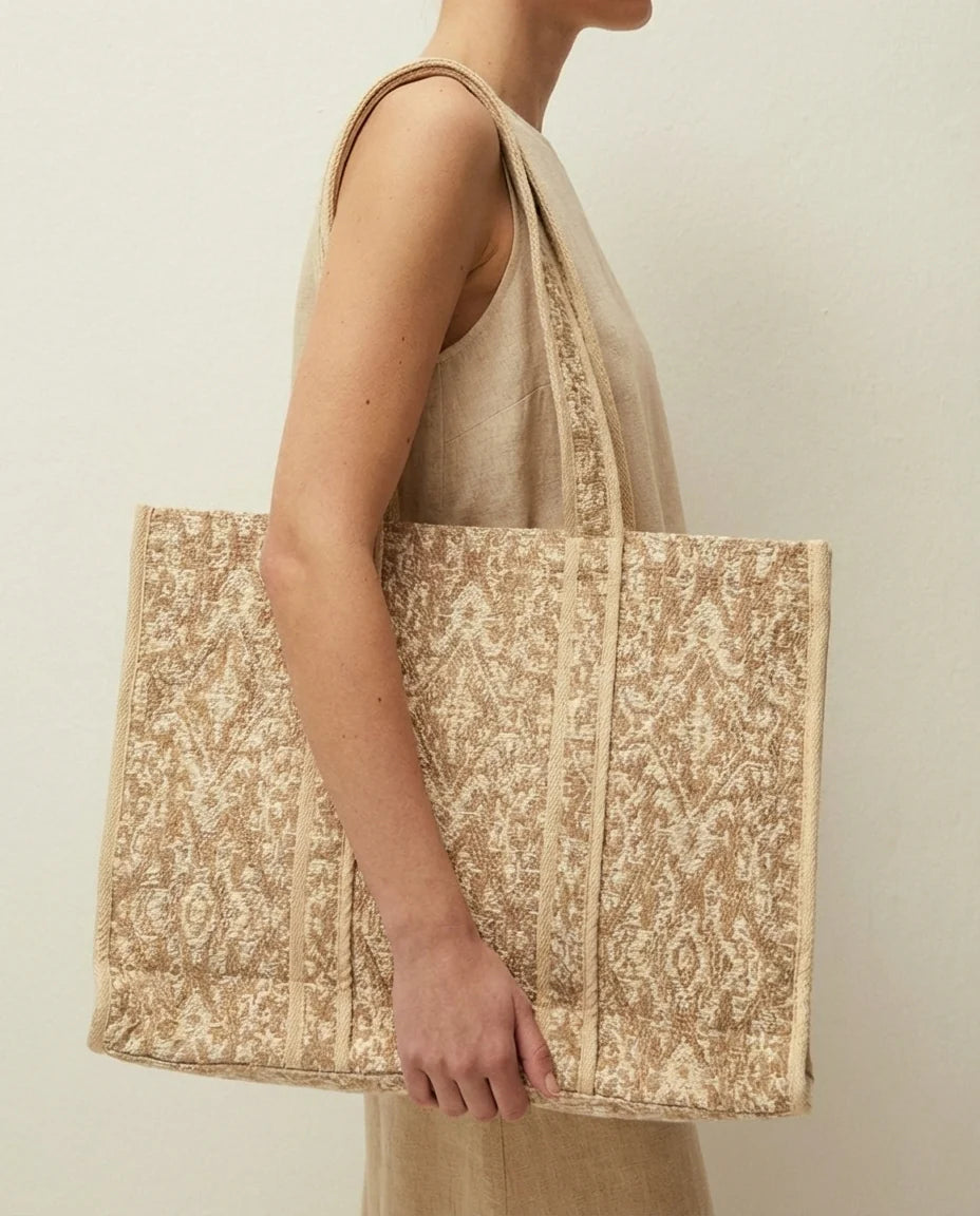 Ampia borsa in tessuto jacquard. Manico corto.