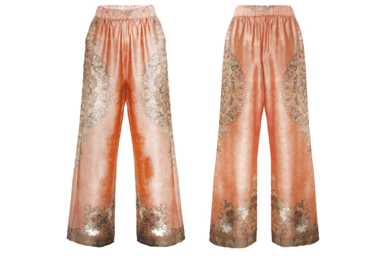 Completo arancio a fantasia floreale con camicia asimmetrica e pantalone palazzo con elastico in vita