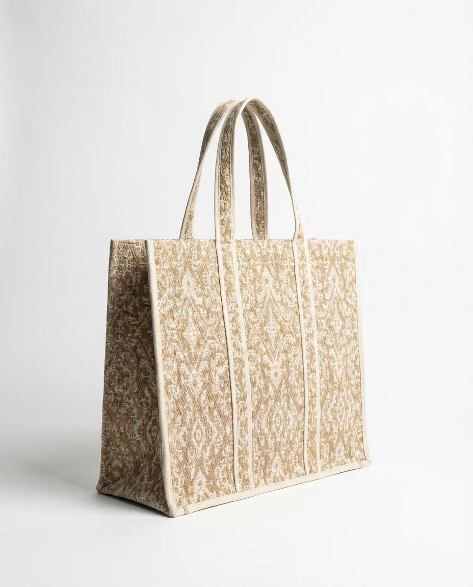 Ampia borsa in tessuto jacquard. Manico corto.