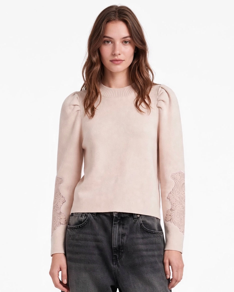 Maglione rosa con arricciatura sulle spalle e ricamo sulla manica