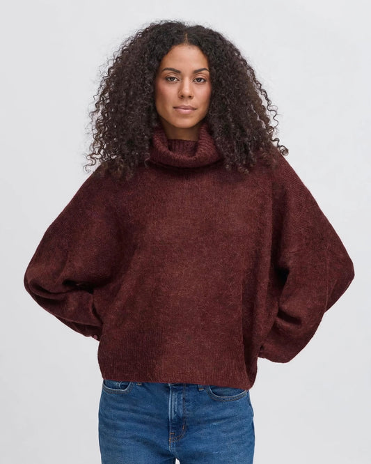 Oversized burgundy turtleneck sweater with buttons on the cuffs