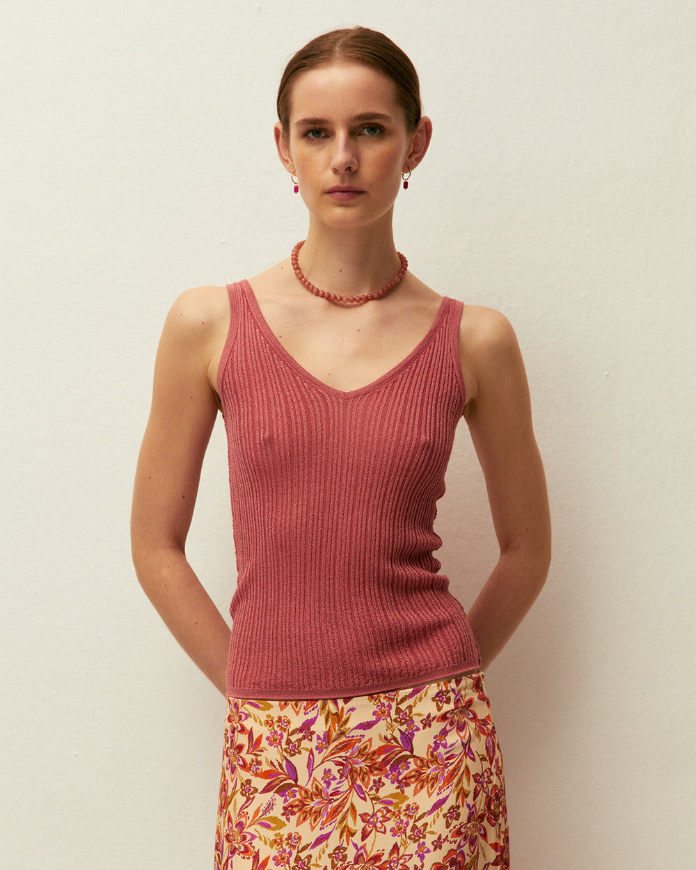 Top corallo con scollo a V e spalline, realizzato in tessuto lavorato a maglia con lurex