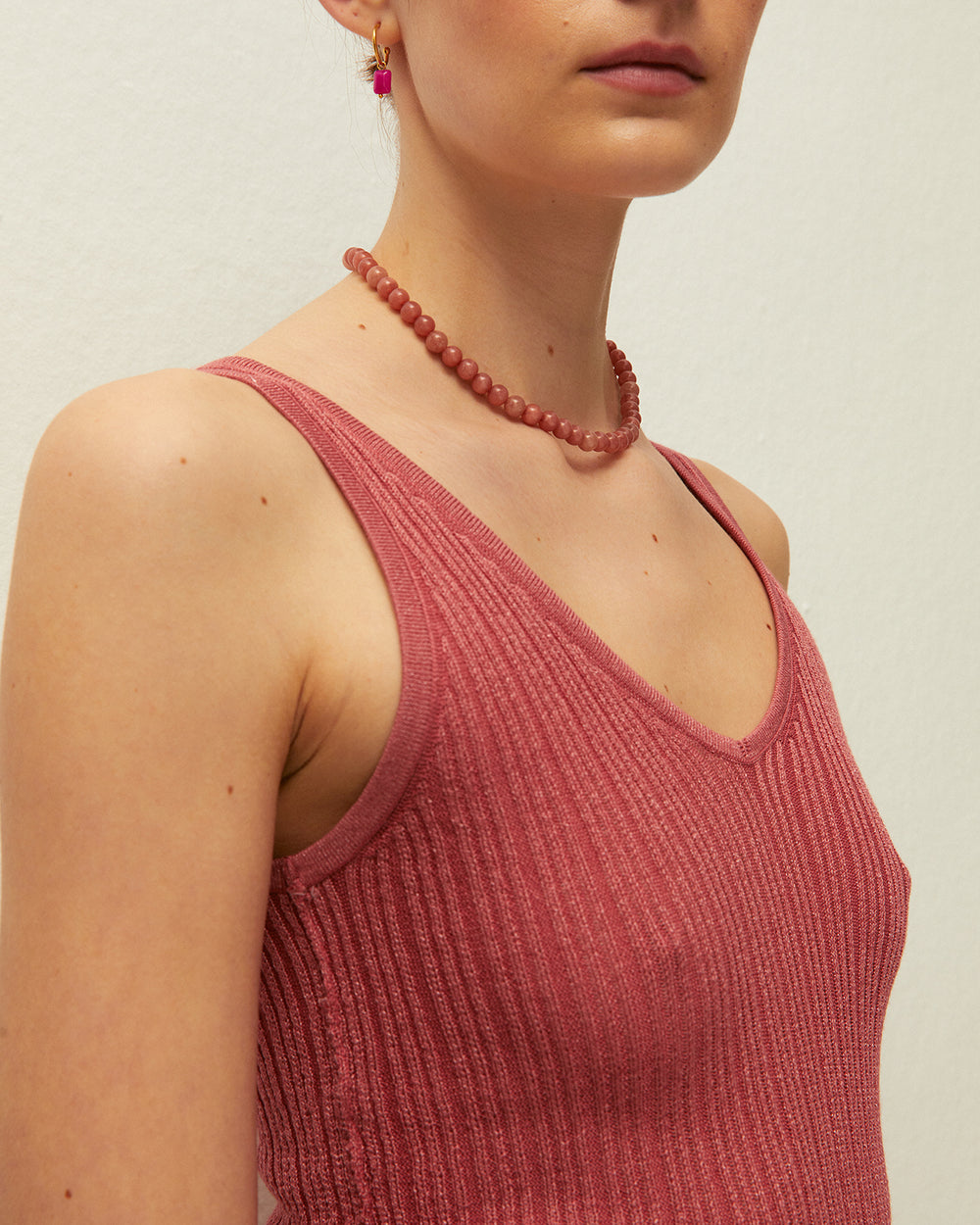 Top corallo con scollo a V e spalline, realizzato in tessuto lavorato a maglia con lurex