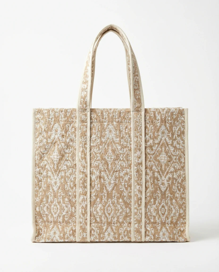 Ampia borsa in tessuto jacquard. Manico corto.