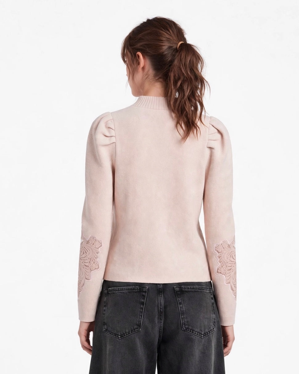 Maglione rosa con arricciatura sulle spalle e ricamo sulla manica