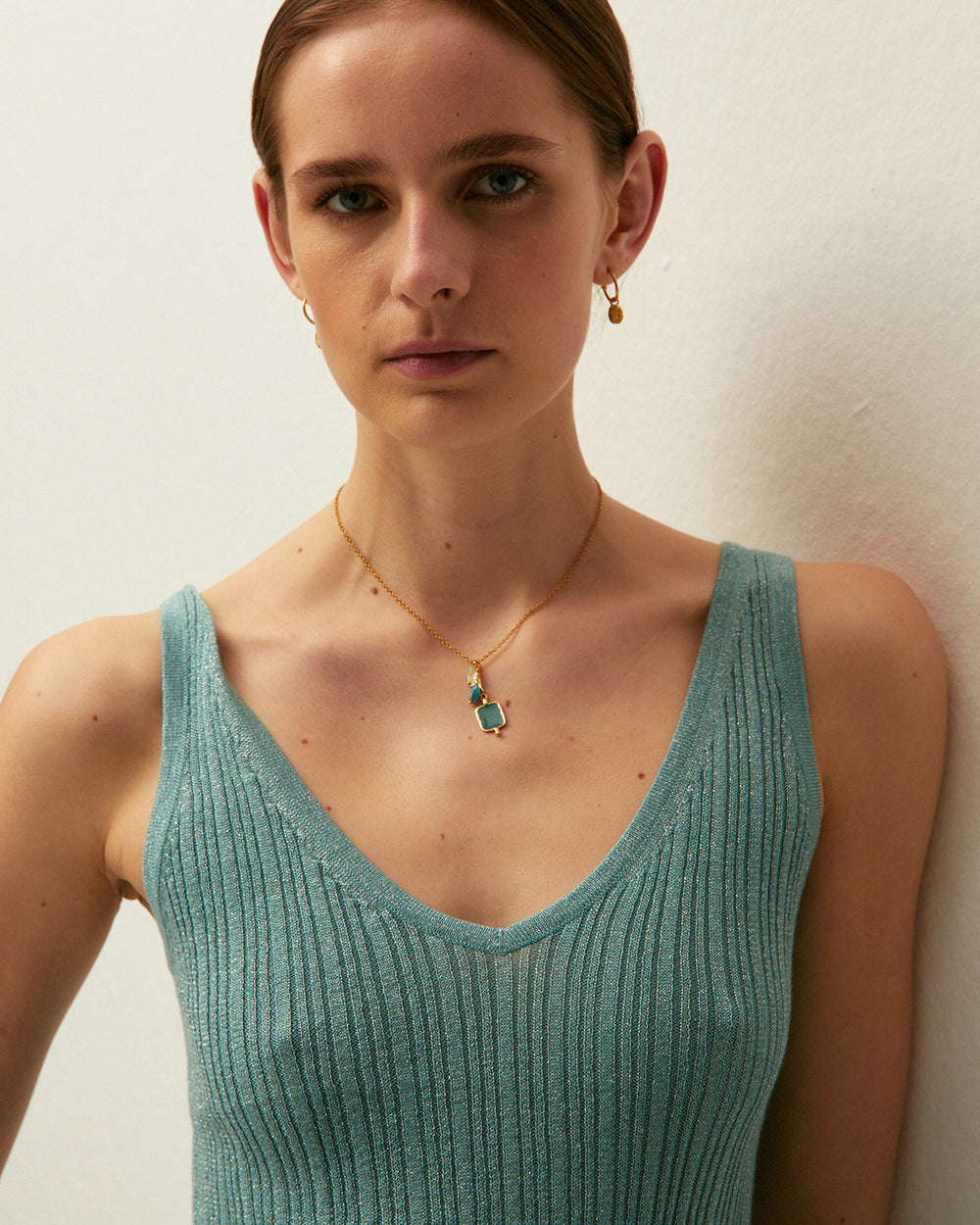Top verde acqua con scollo a V e spalline, realizzato in tessuto lavorato a maglia con lurex