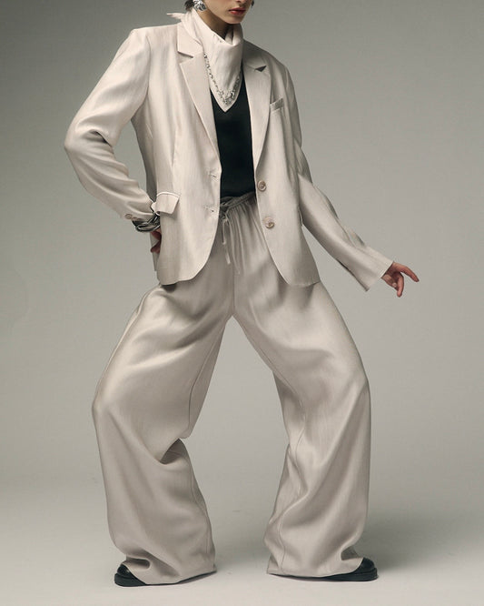 Tailleur grigio giacca 2bottoni con accessorio pietre pantalone palazzo con elastico in vita effetto lucido