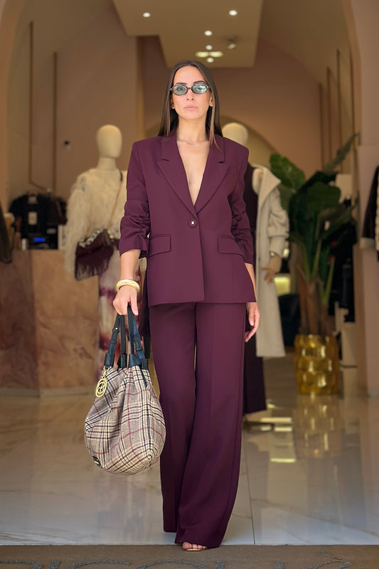 Tailleur vino con blazer con manica drappeggiata e pantaloni ampi a vita alta