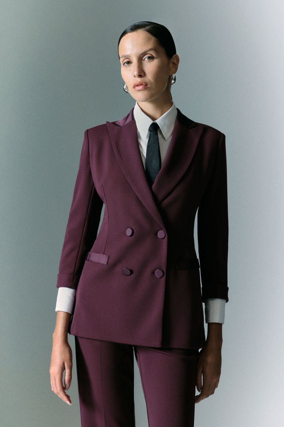 Tailleur prugna con blazer doppiopetto e pantaloni svasati