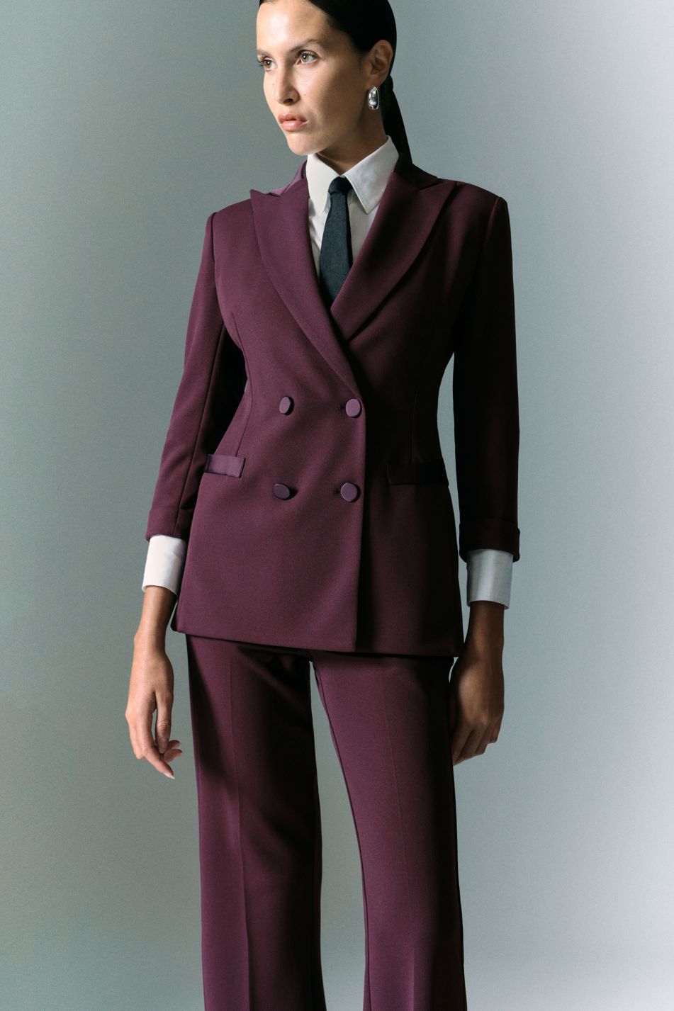 Tailleur prugna con blazer doppiopetto e pantaloni svasati