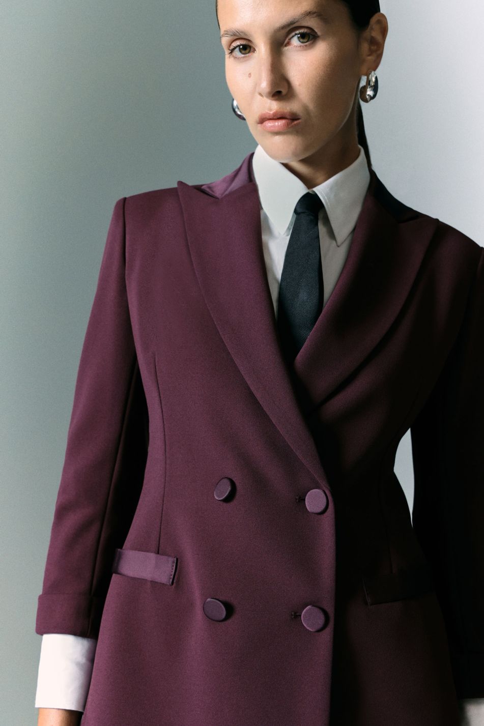 Tailleur prugna con blazer doppiopetto e pantaloni svasati