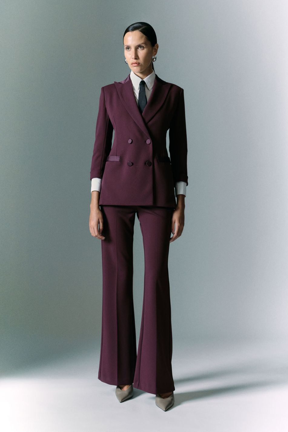 Tailleur prugna con blazer doppiopetto e pantaloni svasati