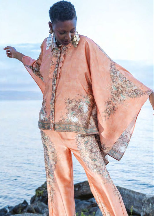 Completo arancio a fantasia floreale con camicia asimmetrica e pantalone palazzo con elastico in vita