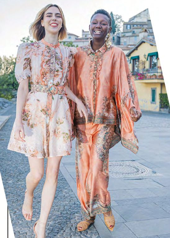 Completo arancio a fantasia floreale con camicia asimmetrica e pantalone palazzo con elastico in vita